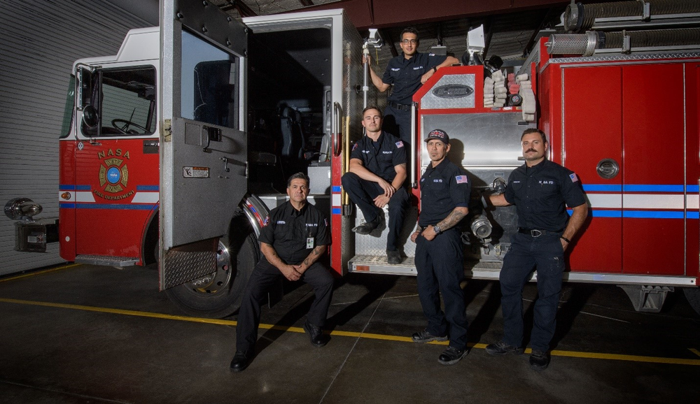 Members of the White Sands Test Facility Fire Dept. pose in front of a fire engine.